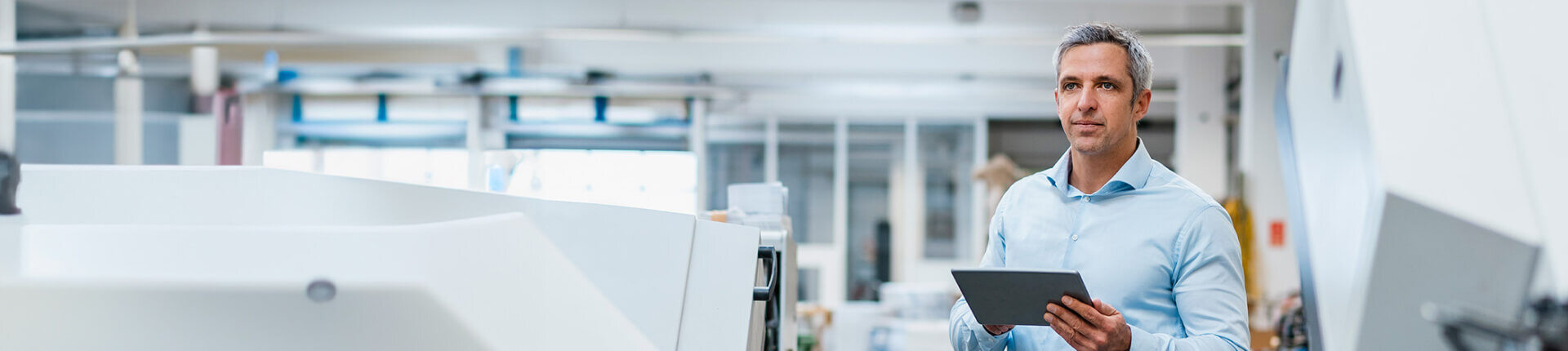man-on-tablet-in-manufacturing-room-1920x430